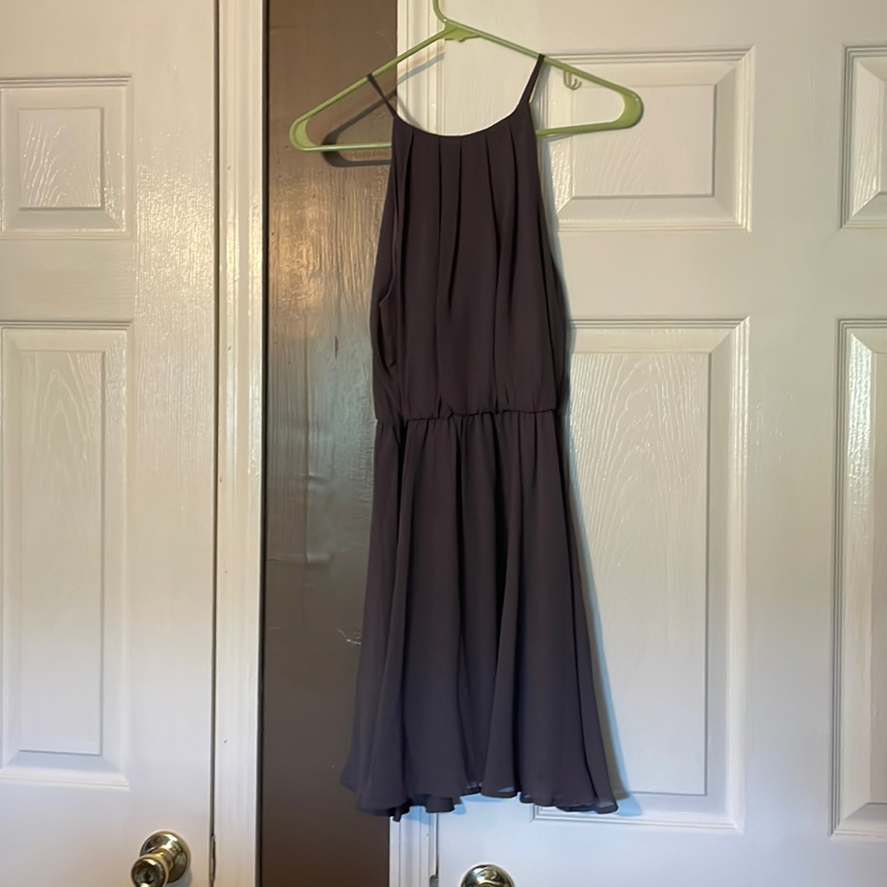 Spaghetti strap mini with flowy skirt and button closure at neck. Lined